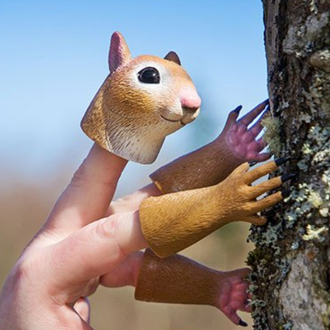 Hand dressed as a squirrel on the side of a tree