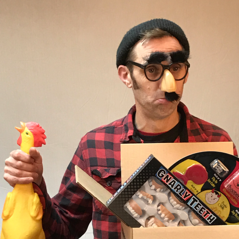 man in mustache glasses holding a rubber chicken