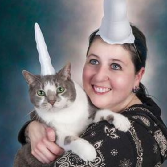 Woman and cat wearing inflatable unicorn horns