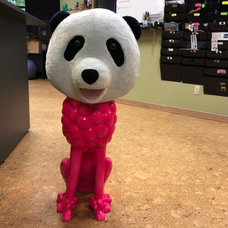 Pink poodle statue wearing a panda head