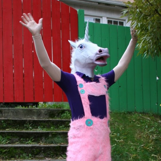 Man in unicorn mask and pink lederhosen on a stairway