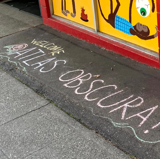 Atlas obscura written in chalk in front of the archie mcphee store