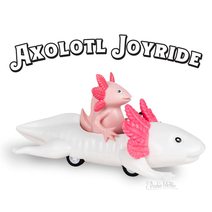 Pink axolotl toy riding on a white axolotl-shaped car toy with wheels, under "Axolotl Joyride" text. Playful and whimsical design showcasing a unique pull-back toy for children and collectors.