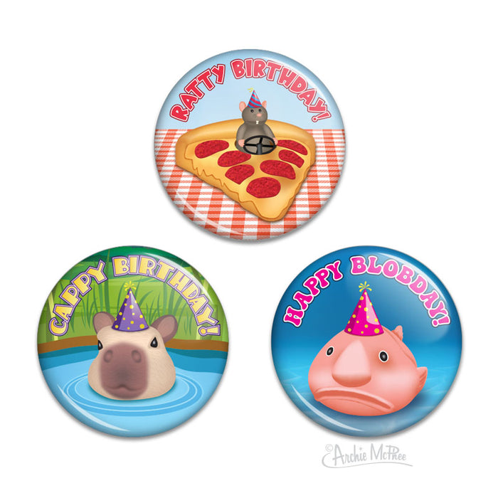 Set of three colorful birthday buttons featuring cartoon animals: a rat driving a piece of pizza, a capybara submerged in a pond, and a blobfish wearing a birthday hat. 