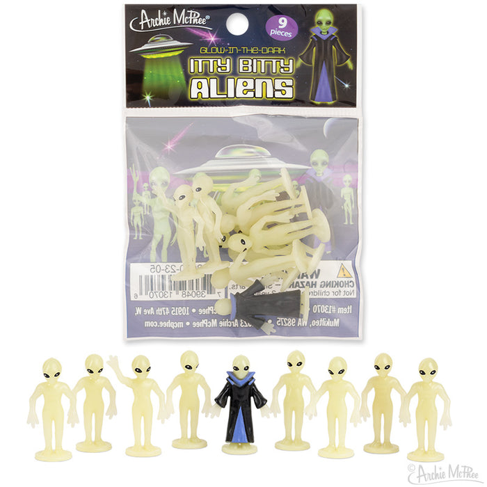 Glow-in-the-dark Itty Bitty Aliens toy set featuring 9 miniature alien figures, including 8 pale yellow aliens and 1 cloaked leader in blue, displayed in packaging with UFO graphics and product information