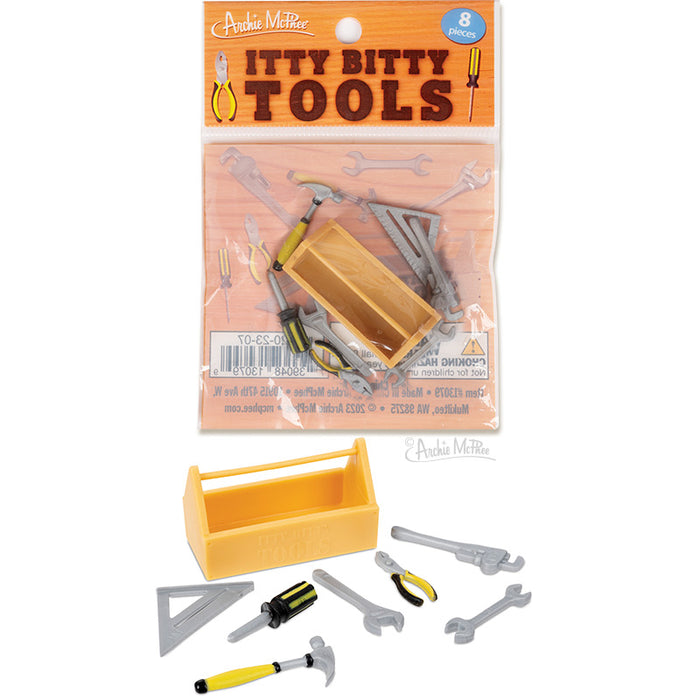 Miniature toy tool set featuring a yellow toolbox and 7 tiny tools including hammer, wrench, and screwdriver. Packaged in a clear bag with orange label reading "Itty Bitty Tools".