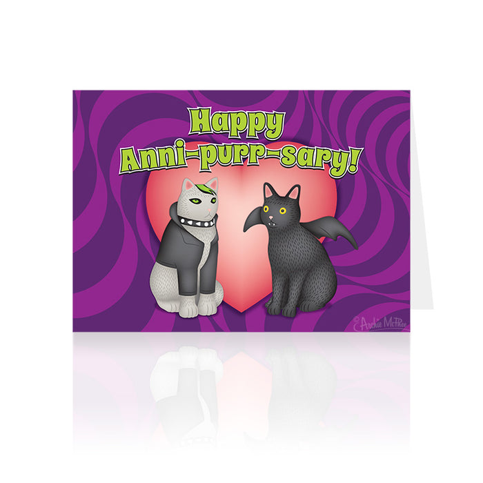 Goth-style anniversary card featuring two cartoon cats, one gray with fishnet stockings and a spiked collar, and one black, sitting in front of a pink heart on a purple swirled background. Text reads "Happy Anni-purr-sary!