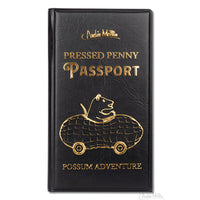 Black cover of a pressed penny passport featuring a possum driving a peanut car