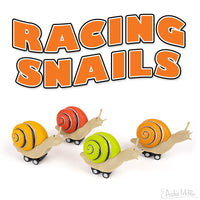 Colorful Racing Snails toy set featuring four vinyl snail figures with orange, yellow, green, and red shells on wheels, displayed beneath bold orange text reading "RACING SNAILS