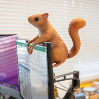 A jaunty latex squirrel clings to a monitor, its paws helpfully blocking part of a spreadsheet. 