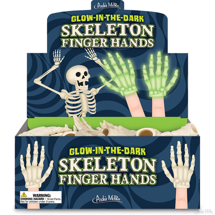 Glow-in-the-dark skeleton finger hands display box featuring a cartoon skeleton and glowing hand illustrations, with multiple skeleton hand toys visible inside the open box below