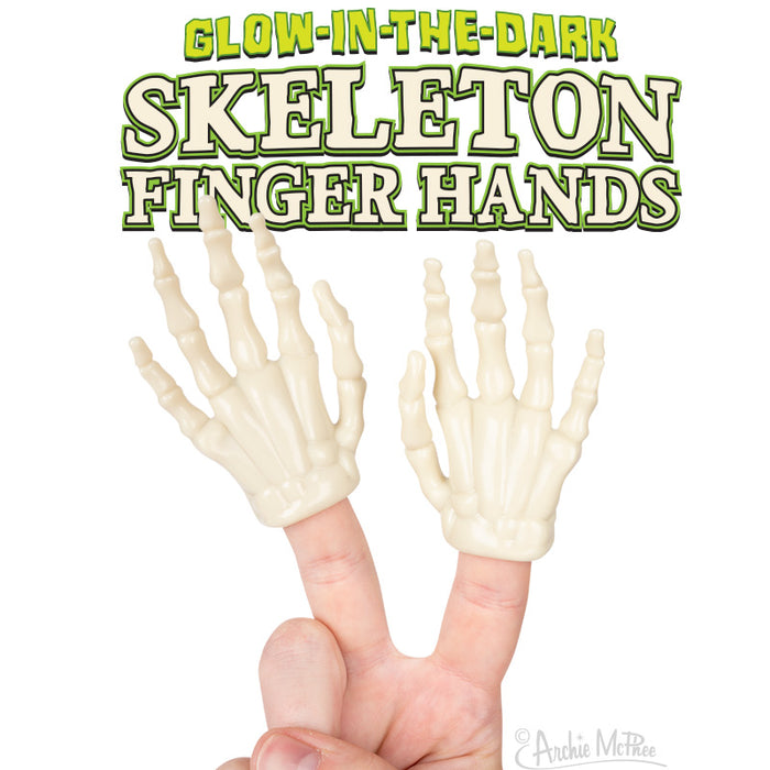 Glow-in-the-dark skeleton finger hands worn on two fingers, displaying bony structures. Text above reads 'GLOW-IN-THE-DARK SKELETON FINGER HANDS' in green and white lettering against a white background.