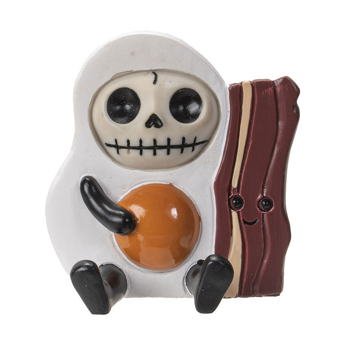 Furrybones Sunny Egg & Bacon figurine: Cute skeleton dressed as fried egg with smiling bacon strip. Collectible skeleton has large eyes, stitched mouth, white egg-shaped body with orange yolk center, and sits beside anthropomorphic bacon slice with happy face.