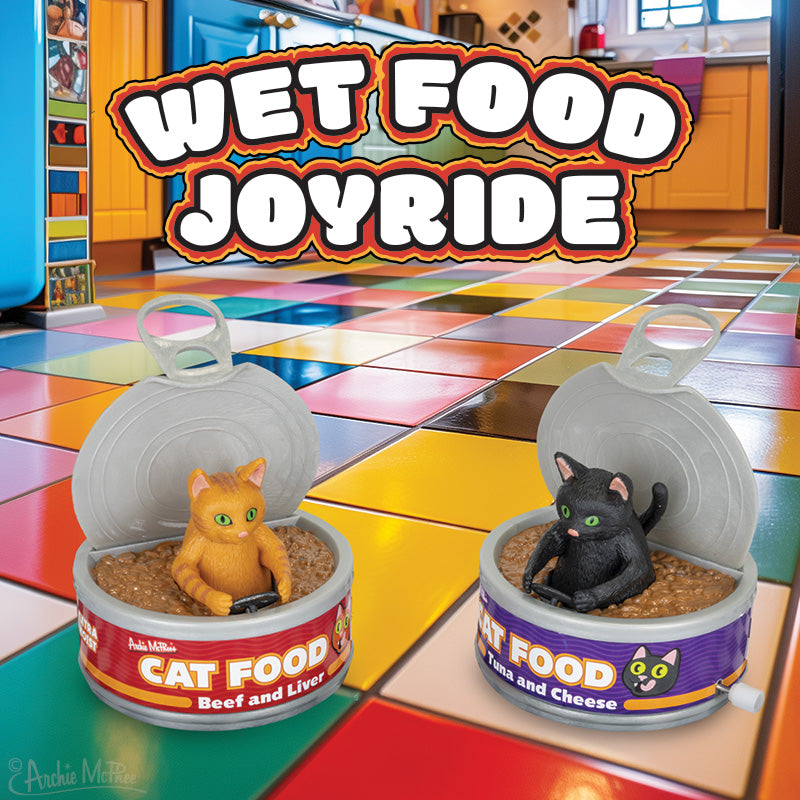 Toy cats in open cans of Wet Food Joyride soft vinyl cat food on a colorful tiled kitchen floor.