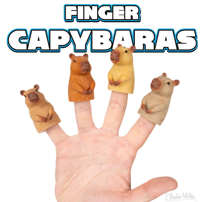 Set of 4 colorful capybara finger puppets on a hand, with text "FINGER CAPYBARAS" above. Puppets show different shades of brown and tan, capturing the cute and calm nature of capybaras. Perfect for playful animal lovers and stress relief.