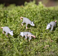 A collection of Itty Bitty Possums sits on green moss, each one blending seamlessly into their surroundings.