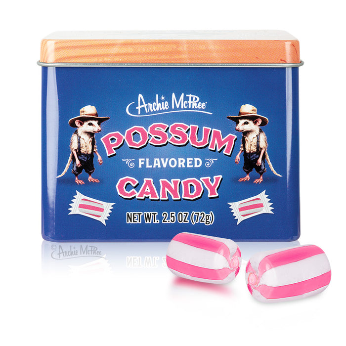 Blue tin container of Archie McPhee's Possum Flavored Candy with orange lid, featuring cartoon possums and product details. Two pink and white striped candies displayed in front of the tin.