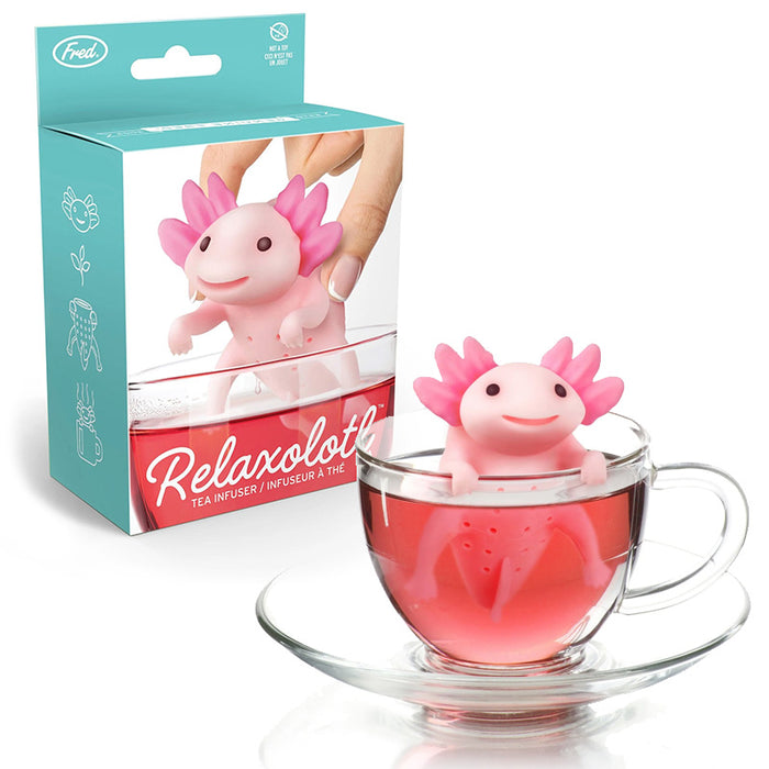 Axolotl-shaped novelty tea infuser sitting in a clear glass of pink tea with the package in the background