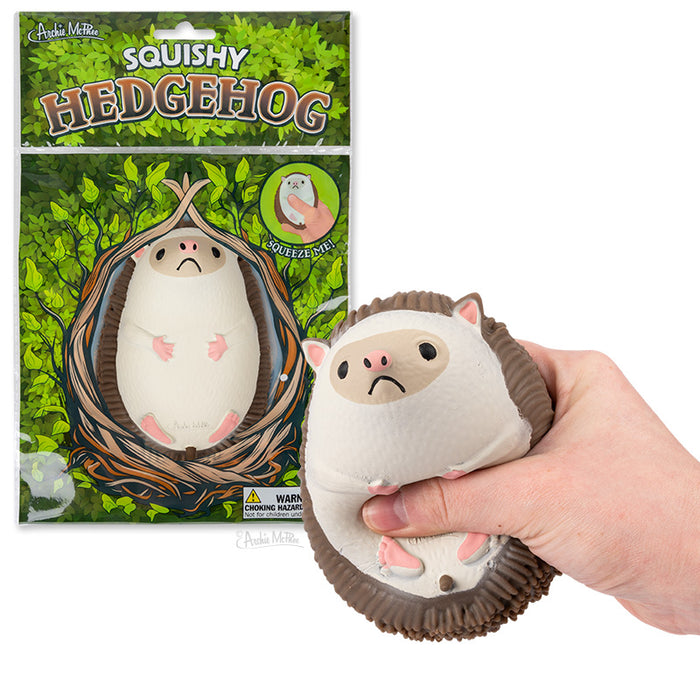 Squishy Hedgehog toy package and product demonstration, showing a soft, cute hedgehog-shaped stress ball being squeezed in a hand, with leafy green packaging design and product details