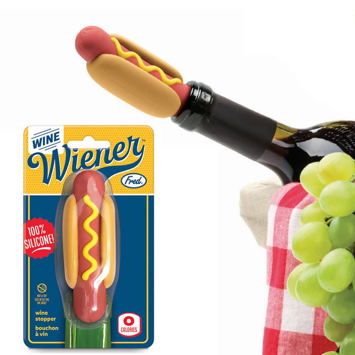 Hot Dog shaped wine bottle stopper inserted into a wine bottle in a basket with green grapes and the Wine Wiener package in the foreground