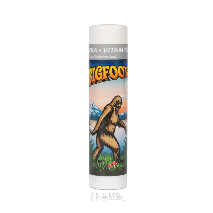 Bigfoot Lip Balm tube featuring colorful illustration of Bigfoot walking in mountain landscape, with product name and vitamin information visible