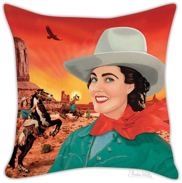 Colorful Western-themed pillow cover featuring smiling cowgirl in foreground with desert landscape, riders on horseback, and soaring eagle in vibrant sunset background