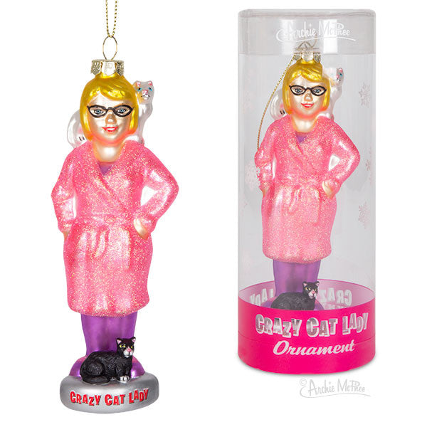 Glass ornament featuring a woman in pink robe and glasses with small cat figures, shown hanging and in packaging labeled 'Crazy Cat Lady Ornament