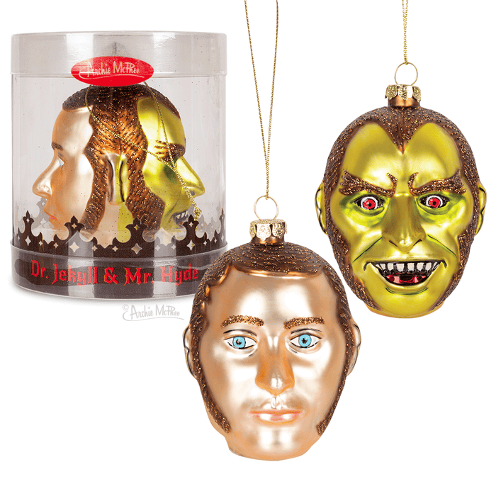 Two-sided glass Christmas ornament featuring Dr. Jekyll and Mr. Hyde characters, with contrasting gold and silver faces displaying good and evil expressions, packaged in a clear cylindrical container with red label.