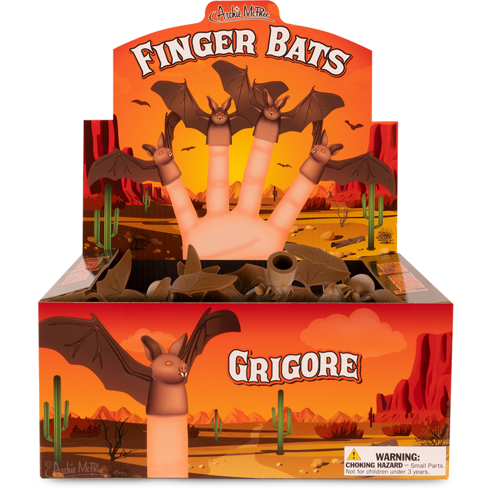 Colorful display box of Finger Bats puppet toys, featuring bat-shaped puppets on fingers against a desert sunset backdrop with cactus silhouettes, showcasing product packaging and design