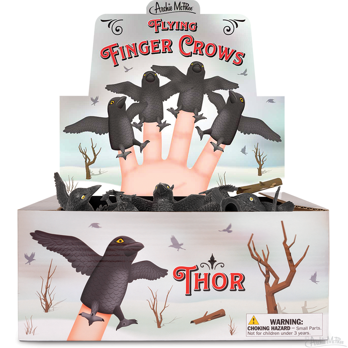 Bulk box display of Flying Finger Crows puppets, showing hand wearing multiple crow puppets in flight pose. Product named Thor visible on box front. Winter landscape background with trees. Warning label for choking hazard included.