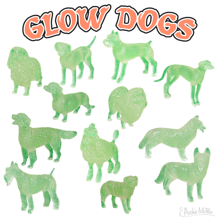 Pack of 12 glow-in-the-dark dog figurines in various breeds and poses, arranged on white background with orange 'GLOW DOGS' text above. Small, soft vinyl toys for collectors or play, approximately 1.5 inches each, glowing green color.