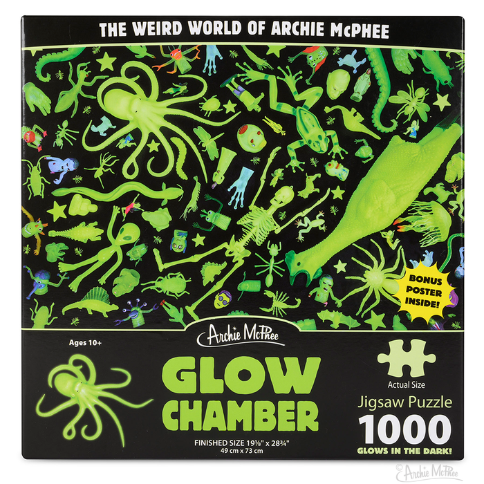 Glow Chamber Puzzle box featuring a chaotic assortment of glowing green toys, creatures, and objects on a black background. The 1000-piece jigsaw puzzle showcases Archie McPhee's weird world, with glow-in-the-dark elements for nighttime puzzle solving.