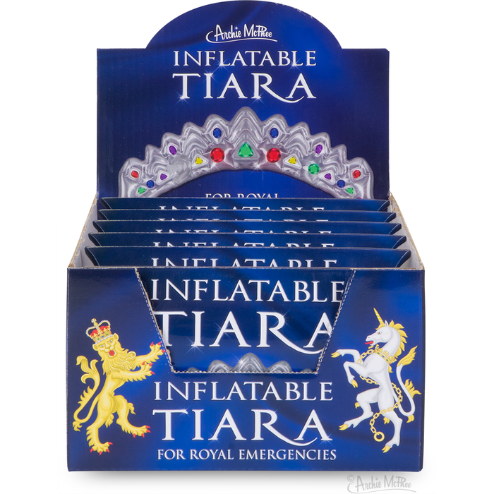 Display box of Inflatable Tiaras by Archie McPhee, featuring colorful crown design and royal lion imagery. Product packaging showcases multiple tiara boxes for bulk purchase, ideal for parties or promotional events.