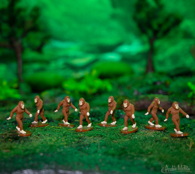eight itty bitty Bigfoot figures in a miniature forest