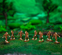 eight itty bitty Bigfoot figures in a miniature forest