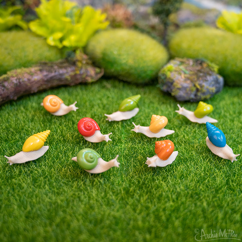 Nine colorful itty bitty snails on a miniature lawn