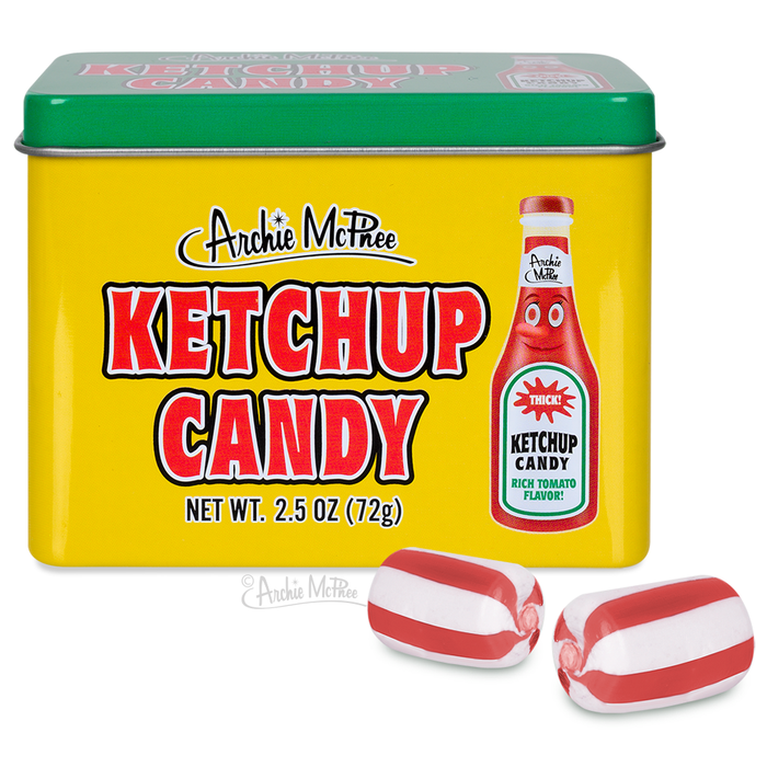 Yellow tin of Archie McPhee Ketchup Candy with green lid, featuring red and white ketchup bottle graphic. Two red and white striped candies displayed in front of tin. Product weight 2.5 oz shown.