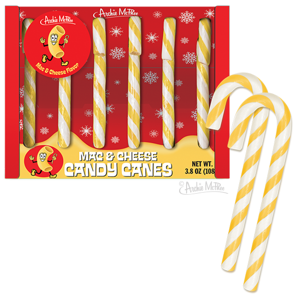 Yellow and white striped Mac & Cheese Candy Canes in festive red packaging with snowflake decorations, featuring a smiling macaroni mascot. Box displays product name and weight, with two candy canes shown separately to highlight the unique color and twist pattern.