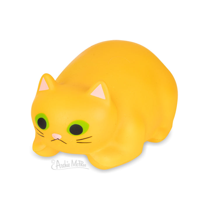 Yellow stress relief cat toy in crouching position with green eyes and pink ears, made of soft foam for squeezing to relieve stress