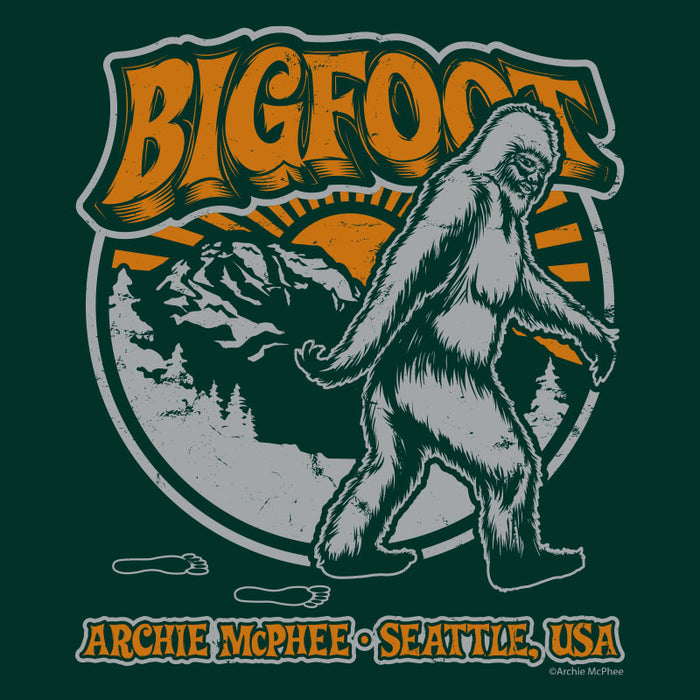 Retro Bigfoot t-shirt design featuring stylized Sasquatch walking in front of mountains and sunset, with groovy orange text and Seattle, USA location. Green background with vintage 70s-inspired artwork perfect for cryptid enthusiasts and fashion-forward shoppers.