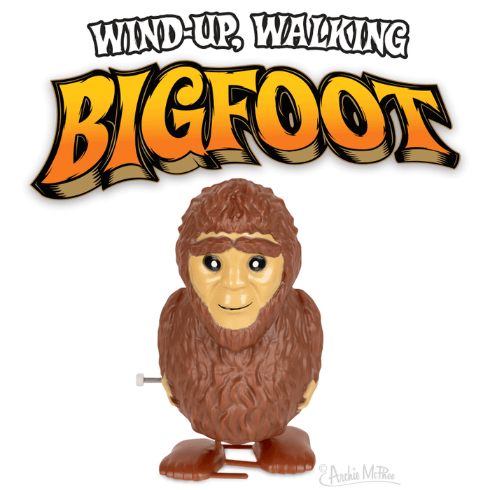 Colorful cartoon wind-up Bigfoot toy with brown fur and smiling face, standing beneath bold orange text reading "Wind-Up Walking Bigfoot