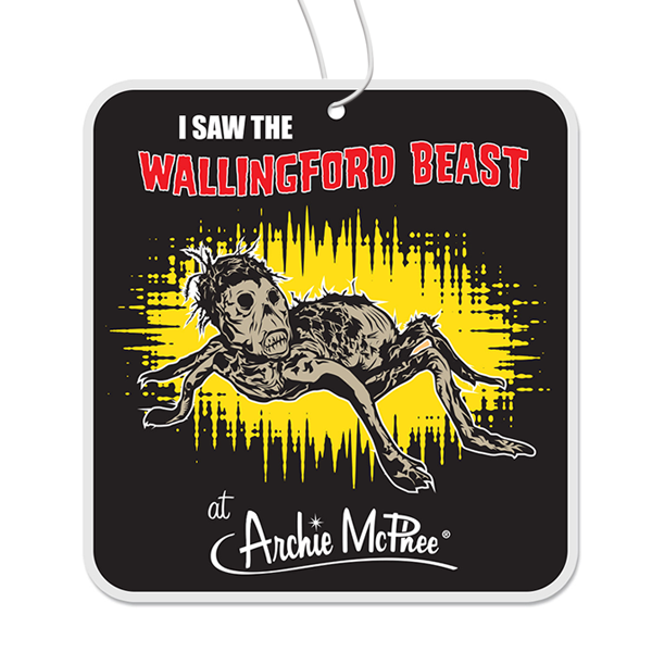 Quirky car air freshener featuring the Wallingford Beast, a cryptozoological creature with wispy hair and black eyes, on a black background with yellow splatter effect. Text reads "I SAW THE WALLINGFORD BEAST at Archie McPhee