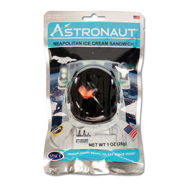 Astronaut Neapolitan ice cream sandwich package featuring a space helmet with Earth view, reflecting an ice cream sandwich inside. Product displayed in freeze-dried, ready-to-eat space food packaging with American flag and weight details.