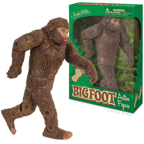 Bigfoot action figure in mid-stride pose, with detailed brown fur and articulated joints, displayed next to its green packaging featuring forest imagery and product name