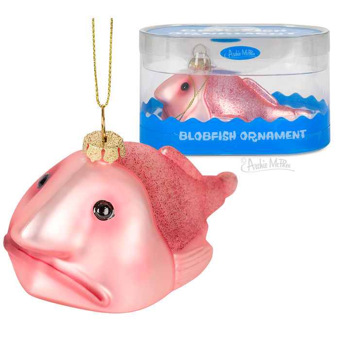 Glittery pink blobfish Christmas ornament with gold hanging string, displayed next to its clear packaging featuring blue waves and product name