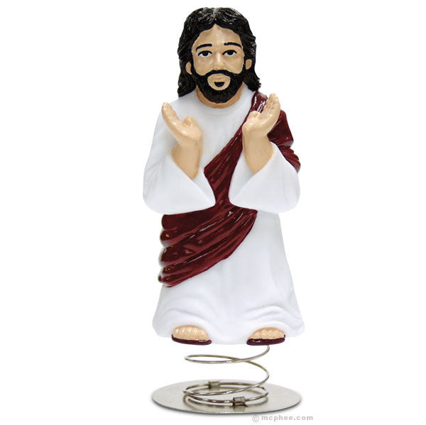 Dashboard Jesus figurine with white robe and red sash, arms raised, standing on metal spring base, ready to bring spiritual guidance to your car's dashboard