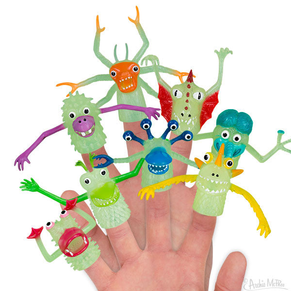 Colorful glow-in-the-dark finger monsters in various whimsical designs, featuring different shapes, eyes, and appendages, worn on fingertips of a hand