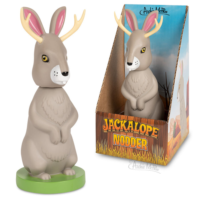 Whimsical Jackalope Nodder figurine with antlers and long ears, standing upright on a green base, next to its colorful product box featuring woodland scenery and 'Jackalope Nodder' text.