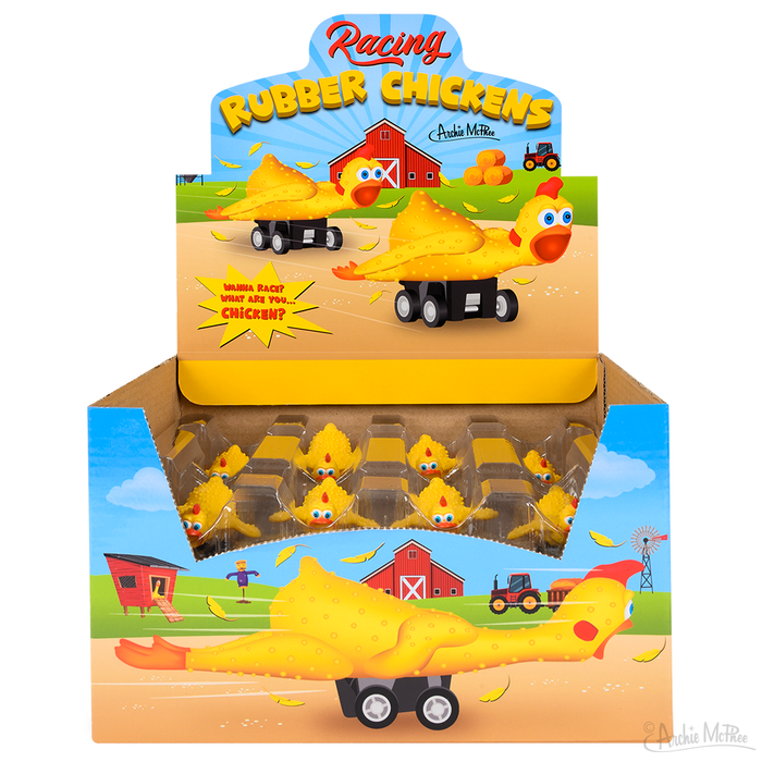 Colorful display box of Racing Rubber Chickens, featuring yellow pull-back toy chickens on wheels in a farm-themed setting with red barn and tractors. Box shows individual chickens and a larger racing chicken toy.