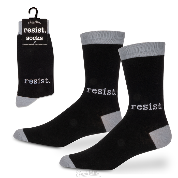 Black crew socks with gray heel, toe, and cuff, featuring 'resist' text in white. Product packaging shows 'resist. socks' branding. Ideal for expressing dissent and activism.